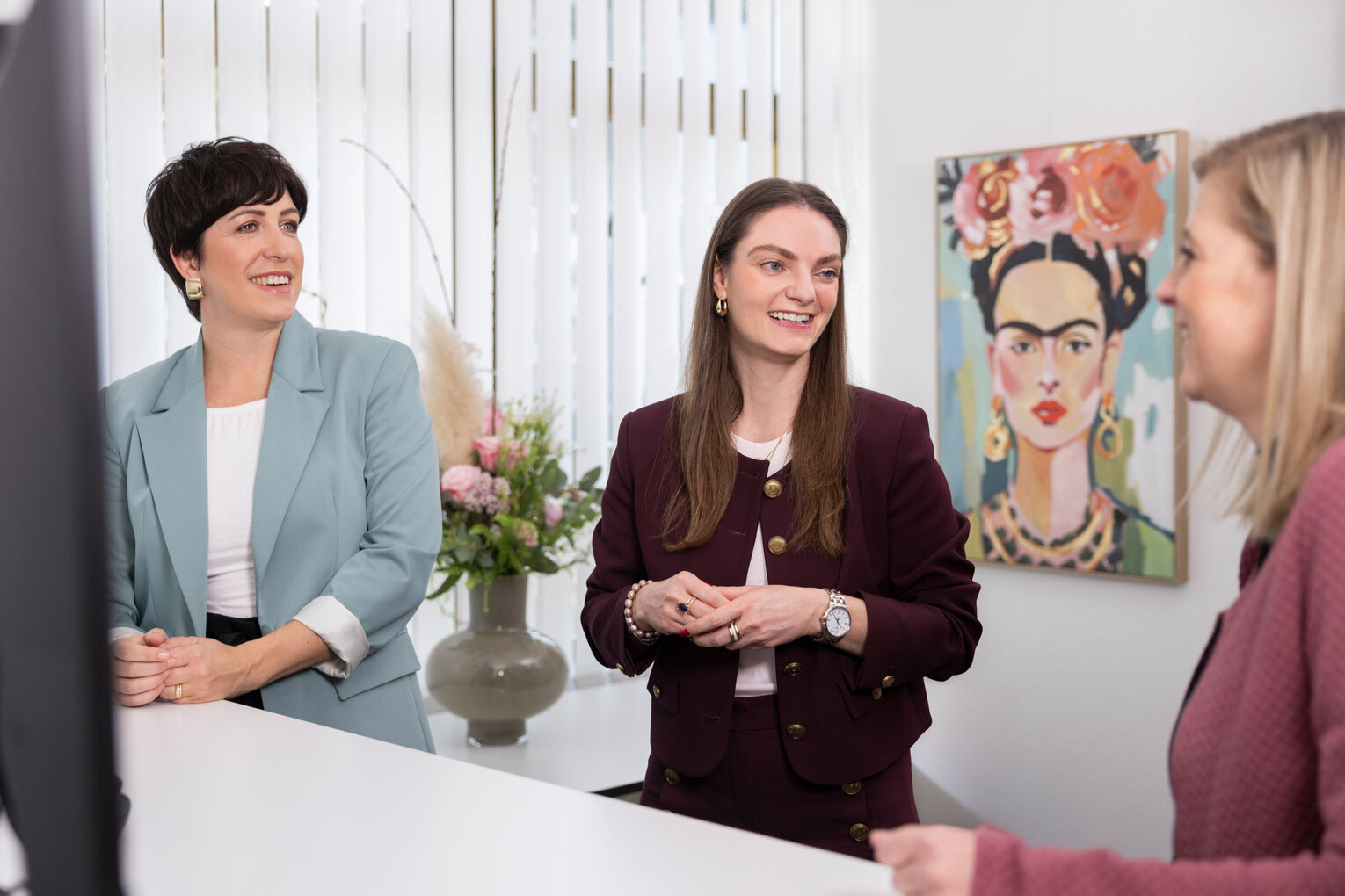 Im Gespräch Nathalie Detsch und Mitarbeiterinnen im Gespräch am Schreibtisch.